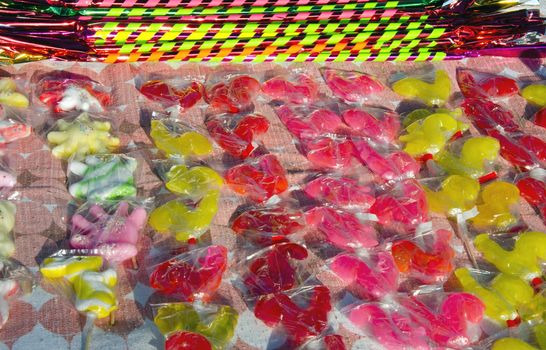 Colorful candy packed in polyethylene sell outdoor street fair in market.