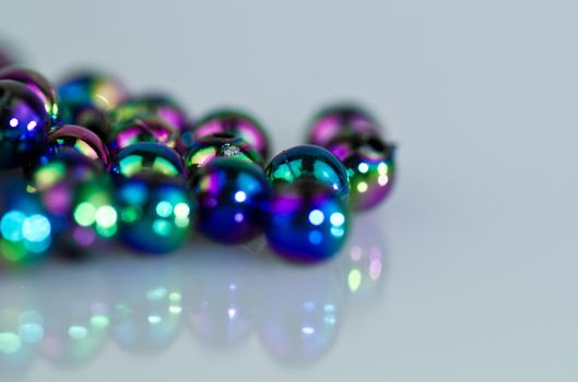 Blue beads on bluish background from left side in landscape orientation