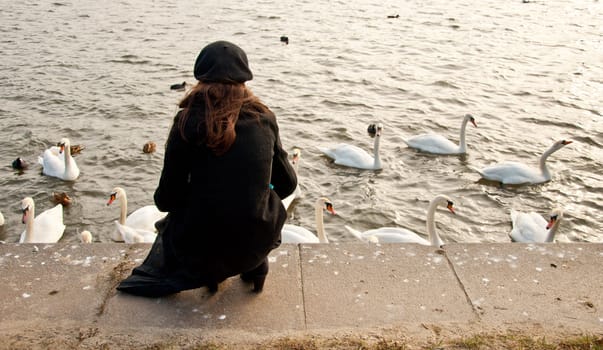 Lonely girl and flock of swans