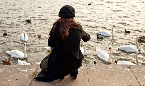 Lonely girl and flock of swans