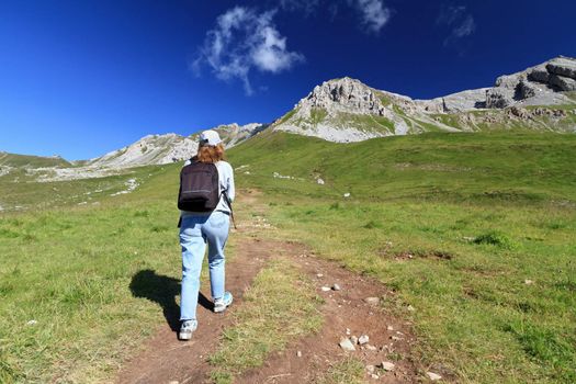 hiker walks on a path in Italian Dolomites