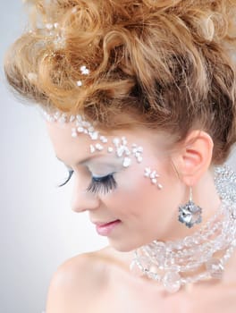 Closeup portrait of young beautiful girl with fantasy winter make-up