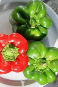 Close up of the red and green bell peppers on a plate.