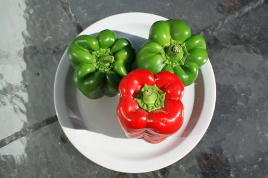 Close up of the red and green bell peppers on a plate.