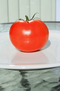 Close up of a red tomato on a plate.
