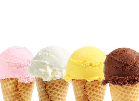 Assorted ice cream in sugar cones on white background