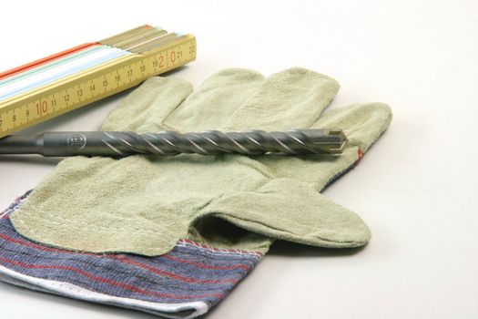 contruction concepts meter drill and working gloves in white background