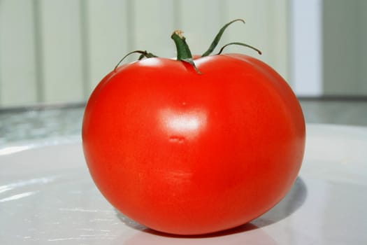 Close up of a red tomato on a plate.
