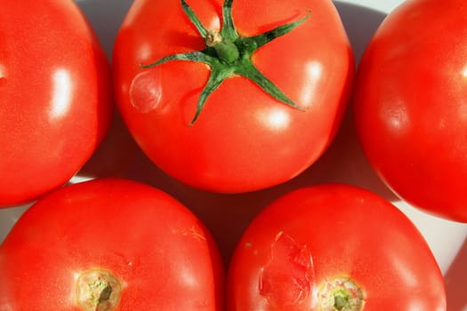 Close up of the red tomatos on a plate.
