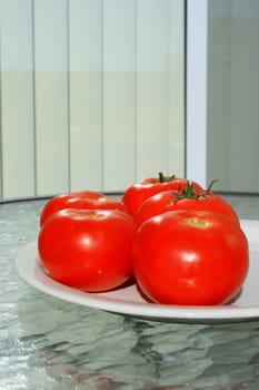 Close up of the red tomatos on a plate.
