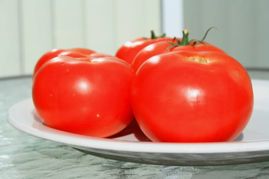 Close up of the red tomatos on a plate.
