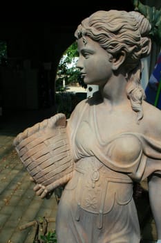 Close up of a statue of a young woman.
