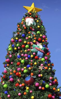Christmas tree decorated with bright colorful ornaments outside