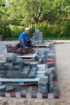 Worker resting at the end of new cobbled street