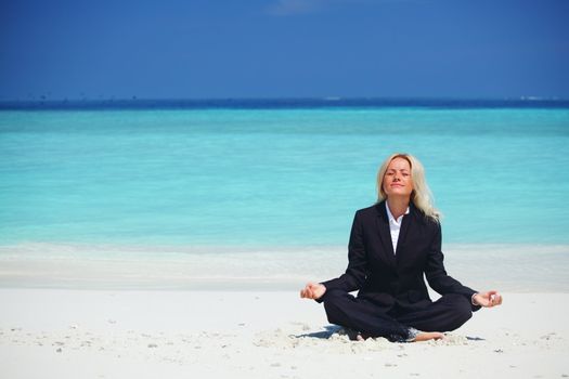 yoga business woman in lotus pose on the beach