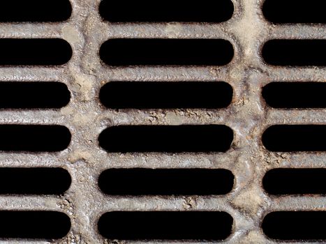 Old rusty metal sewer manhole lid covering street