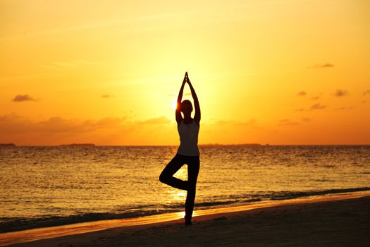 sunset yoga woman on sea coast