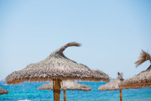 Close up of straw sun umbrella at tropical beach