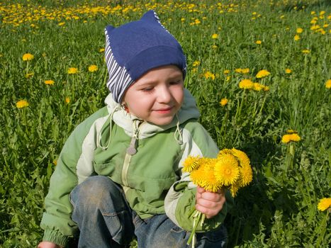 Little child with flower on grass and blue sky
