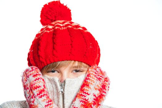 Close up portrait of young smiling cute teenager in a red hat and mittens, isolated on white