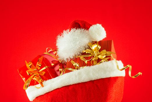 Christmas presents with Santa's hat against red background