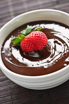 Fresh strawberry dipped in melted chocolate in bowl