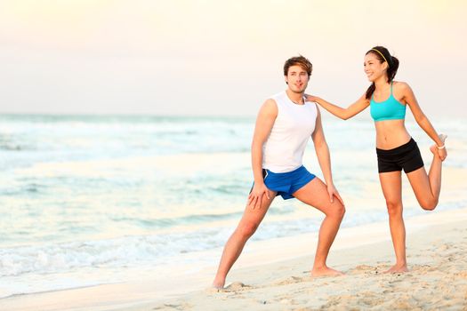 Couple doing stretching exercises workout training on beach. Young interracial running couple stretching after jogging outdoors on beautiful beach. Asian woman fitness model, Caucasian man.