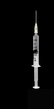 Plastic syringe with clear water inside isolated on black background