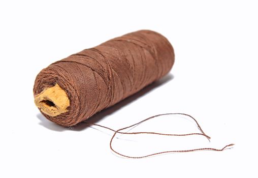 spool of the brown threads on white background