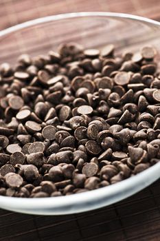 Glass bowl of sweet dark chocolate chips