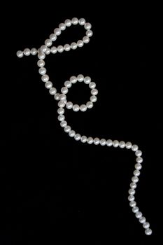 White pearls on the black velvet  background