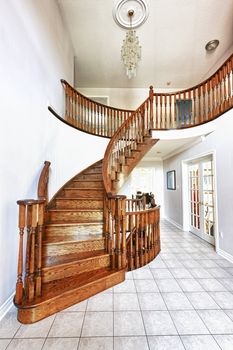 Curved oak staircase in luxury home entrance hall