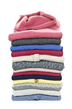 Stack of warm sweaters isolated on white background