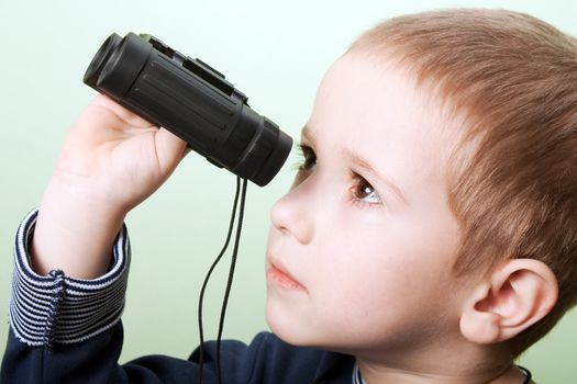 Little child boy looking binoculars lens isolated