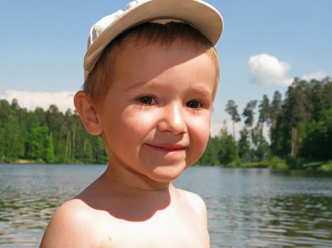 Little child smiling on water beach at summer