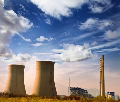 Landscape photo of industrial factory with power chimneys in blue sky in rurial area