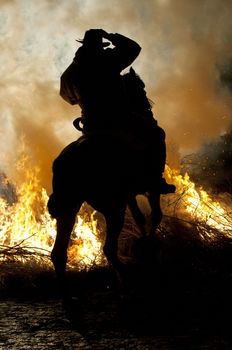 rider jumps the fire with his horse