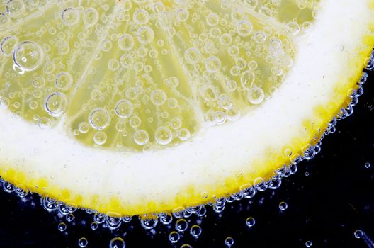 Close-up of a lemon slice with bubbles