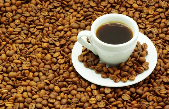 white cup with coffee costing on a coffee grain
