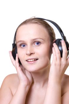 Portrait of an attractive enigmatic  blue-eyes girl with headphones, standing against isolated white background
