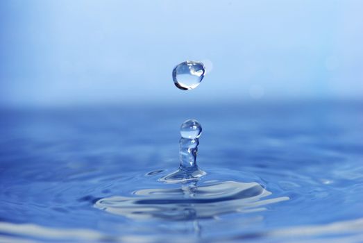The round transparent drop of water falls downward