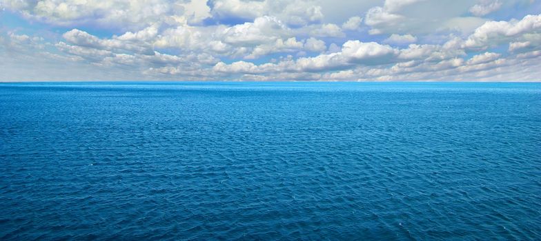 cloudy blue sky above a surface of the sea