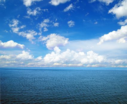 cloudy blue sky above a surface of the sea