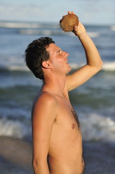 Man refreshing on the beach with a coconut