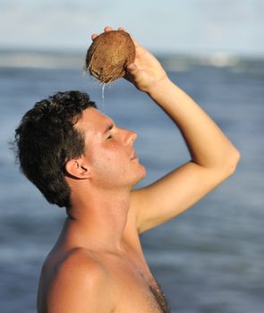 Man refreshing on the beach with a coconut