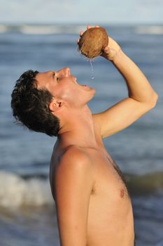 Man refreshing on the beach with a coconut