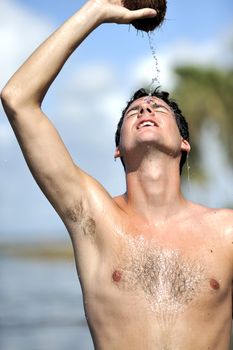 Man refreshing on the beach with a coconut