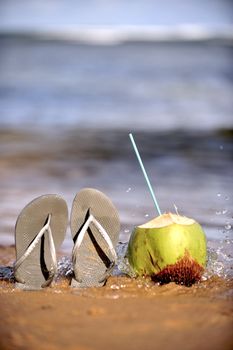 Thongs and coconut on the beach in Brazil.