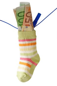 Baby socks and euro banknotes on aclothline. Isolated on white background.