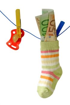 Baby socks with pacifier and euro banknotes on aclothline. Isolated on white background.